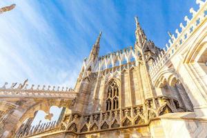 dak van de kathedraal van Milaan Duomo di Milano met gotische torenspitsen en witmarmeren beelden. top toeristische attractie op piazza in milaan, lombardia, italië. brede hoekmening van oude gotische architectuur en kunst. foto