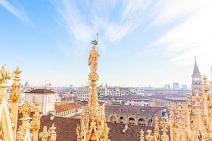 dak van de kathedraal van Milaan Duomo di Milano met gotische torenspitsen en witmarmeren beelden. top toeristische attractie op piazza in milaan, lombardia, italië. brede hoekmening van oude gotische architectuur en kunst. foto