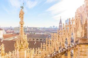 dak van de kathedraal van Milaan Duomo di Milano met gotische torenspitsen en witmarmeren beelden. top toeristische attractie op piazza in milaan, lombardia, italië. brede hoekmening van oude gotische architectuur en kunst. foto