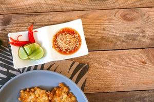 maïs beignets met Chili saus geplaatst Aan een houten tafel foto