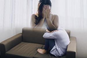 Aziatisch Dames met spanning, ze gehouden haarzelf alleen in haar slaapkamer, depressie. foto