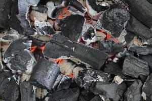 heet oranje brandend steenkool Aan een barbecue grillen. foto