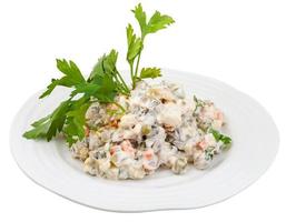 Russisch salade met mayonaise versierd met kruid foto