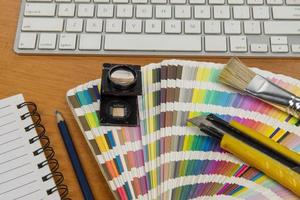 kleur schaal met stylus en vergroten glas Aan het en een notitieboekje foto