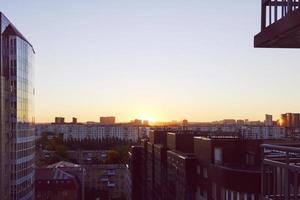 de zon stijgt bovenstaand de horizon verhelderend de huizen en straten van de slapen stad foto