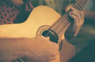 dichtbij omhoog van handen spelen akoestisch gitaar foto