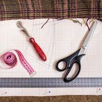 snijdend tafel met kleding stof, patroon, maatwerk gereedschap foto