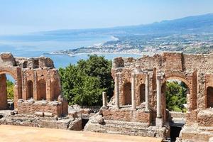 visie van geruïneerd teatro greco en Ionische zee kust foto