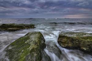 zonsopkomst over- de zee met langzaam Luik en golven vloeiende uit foto