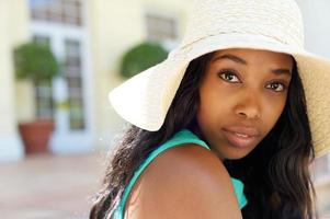 elegante jonge zwarte vrouw buitenshuis met zonnehoed