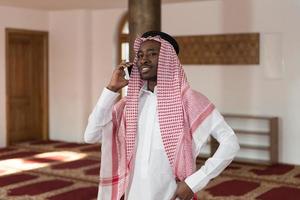 knappe man van het Midden-Oosten praten op mobiele telefoon foto