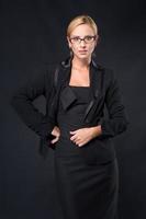 elegantie stijlvolle zakenvrouwen met een bril in zwarte jurk foto