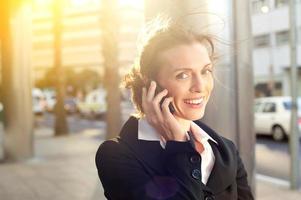 Glimlachende zakenvrouw praten op mobiele telefoon
