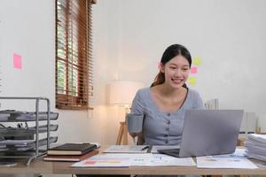 portret van jong vrouw gebruik makend van laptop computer Bij de kantoor, leerling meisje werken Bij huis. werk of studie van huis, Aziatisch vrouw freelance, bedrijf, levensstijl concept foto