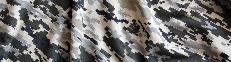 kleding stof met structuur van oekraïens leger korrelig camouflage. kleding met camo patroon in grijs, bruin en groen pixel vormen. officieel uniform van oekraïens soldaten foto