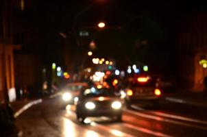 wazig nacht tafereel van verkeer Aan de rijweg. onscherp beeld van auto's op reis met lichtgevend koplampen. bokeh kunst foto