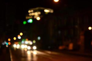 wazig nacht tafereel van verkeer Aan de rijweg. onscherp beeld van auto's op reis met lichtgevend koplampen. bokeh kunst foto