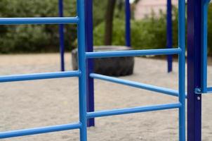 blauw metaal pijpen en dwarsbalken tegen een straat sport- veld- voor opleiding in atletiek. buitenshuis atletisch Sportschool apparatuur. macro foto met selectief focus en extreem wazig achtergrond