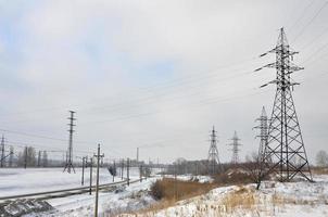 winter landschap met torens van transmissie lijnen foto