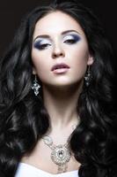 elegant mooi meisje met zilveren make-up en zwarte krullen. foto
