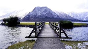 houten brug lood naar de hallstatt meer landschap met sneeuw bergen, hallstatt, Oostenrijk foto