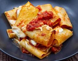 Italiaans pasta paccheri alla sorrentina met tomaat saus en Mozzarella. detailopname. foto