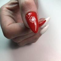 vrouwen rood manicure met een paardebloem patroon Aan de nagel foto