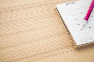 kalender bladzijde met pen punt Bij 25e datum Aan hout tafel achtergrond foto