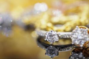 luxe goud sieraden diamant ringen met reflectie Aan zwart achtergrond foto