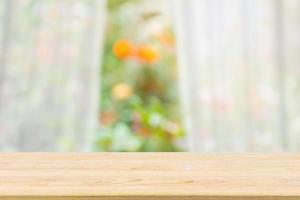 leeg hout tafel top met vervagen wit gordijn venster en groen tuin achtergrond voor Product Scherm sjabloon foto