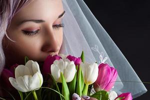 mooie vrouw gezicht met een boeket tulpen