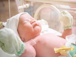 nieuw geboren baby zuigeling slaap in de incubator Bij ziekenhuis foto