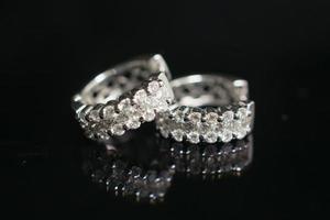 sieraden diamant oorbellen Aan zwart achtergrond met reflectie foto