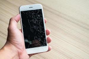 hand- Holding mobiel telefoon met gebroken glas scherm foto
