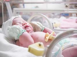 nieuw geboren baby zuigeling slaap in de incubator Bij ziekenhuis foto