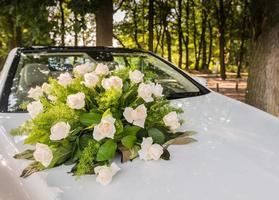 boeket rozen op de auto van de bruid foto