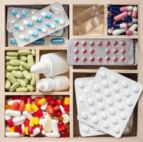 medische pillen en ampullen in houten kist foto