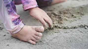 dichtbij omhoog portret van kinderen voeten en hand- spelen met zand. zintuiglijk onderwijs met natuur concept. zomer reizen vakantie recreatie. gelukkig familie tijd. kinderjaren en aan het leren. strand vakantie. foto