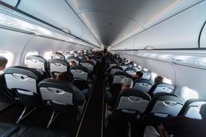 vliegtuig cabine stoelen met passagiers. economie klasse van nieuw goedkoopste goedkoop luchtvaartmaatschappijen. reizen reis naar een ander land. turbulentie in vlucht. foto