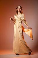 elegante vrouw in gouden jurk met wijnglas