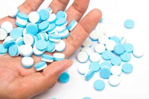 witte en blauwe tabletten pillen bij de hand