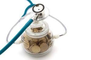 stethoscoop met munten in de besparingen, financieel concept foto