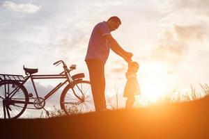 vader en zoon plezier op zonsondergang foto