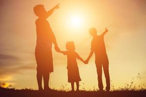 silhouet van een gelukkig familie en gelukkig tijd zonsondergang foto