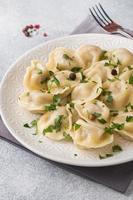 traditioneel pelmeni, ravioli, knoedels gevulde met vlees Aan bord, Russisch keuken foto