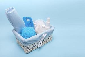 douche en lichaam zorg accessoires in een mooi mand Aan een blauw achtergrond met ruimte voor tekst foto