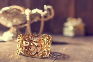 gouden armband en zilveren vaas met juwelen op houten achtergrond foto