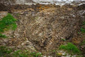 zwaar voertuig sporen Aan aarde oppervlakte onder zomer regen foto