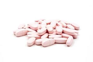 roze pillen op witte achtergrond foto