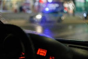 wazig stuurinrichting wiel en auto dashboard met wazig nacht straat achtergrond foto